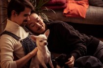 Homosexuell männlich exotisch pärchen relaxen mit hund bei zuhause — Stockfoto