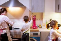 Familie in der Küche. Mutter mit ihren zwei Kindern beim Kochen — Stockfoto