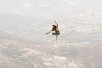 Uma menina equilibrando com uma posição de ioga em um Highline em Los Frailes — Fotografia de Stock