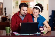 Couple work on laptop computer at home — Stock Photo