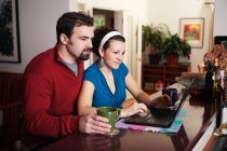 Trabalho de casal no computador portátil em casa — Fotografia de Stock