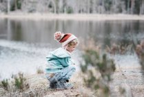 Junges Mädchen sitzt lächelnd auf einem Felsen beim Wandern in Schweden — Stockfoto