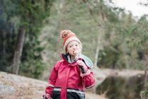 Junges Mädchen isst Marshmallows beim Zelten in einem Wald in Schweden — Stockfoto
