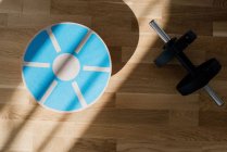 Balance board and weights home exercise equipment on a floor — Stock Photo
