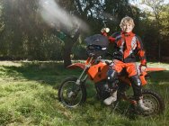 12 year old boy having a break on his off road motorbike — Stock Photo