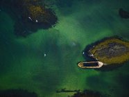 Воздушный вид на остров и лодку в море — стоковое фото