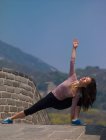 Женщина, практикующая йогу на Великой Китайской стене — стоковое фото