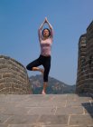 Mulher praticando ioga na Grande Muralha da China — Fotografia de Stock