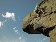 Hombre de bouldering en grilla de piedra en el Peak District / Reino Unido - foto de stock