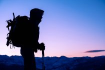 Mujer joven de pie en la cima de la montaña durante el amanecer en Montana - foto de stock