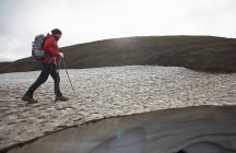 Senderista femenina en Laugarvegur Trail cruzando un campo de nieve - foto de stock