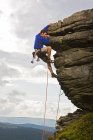 Скалолаз на скале в Пик-Дистрикт в Англии — стоковое фото