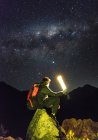 Молодой человек, сидящий на камне в горах Анд, наблюдая за торжеством — стоковое фото