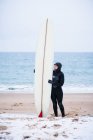 Young woman going surfing in winter snow — Stock Photo
