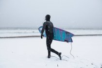Человек готовится к серфингу в зимний снег — стоковое фото