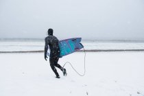 Uomo che fa surf durante la neve invernale — Foto stock