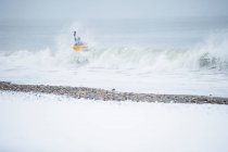 Homem surfando durante a neve de inverno — Fotografia de Stock