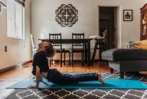 Junge macht Yoga im Wohnzimmer während der Isolation — Stockfoto