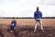 Мальчик и его отец запускают дрон весной — стоковое фото