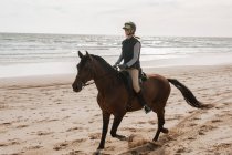 Жінка їде верхи на коні Андалусії на пляжі і посміхається — стокове фото