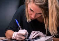 Artista del tatuaje mujer dibuja un tatuaje - foto de stock