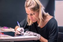 Татуировщица рисует татуировку — стоковое фото