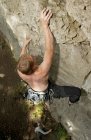 Молодой человек, карабкающийся по известняковой скале в Северной Германии — стоковое фото
