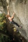 Joven escalando un acantilado de piedra caliza en el norte de Alemania - foto de stock