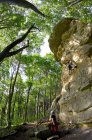 Mujer madura escalando un acantilado de piedra caliza en el norte de Alemania - foto de stock