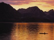 Hombre viajando en un kayak de mar a través de los fiordos del este de Groenlandia - foto de stock