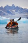 2 hombres viajando en un kayak de mar a través de los fiordos del este de Groenlandia - foto de stock