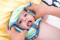 Visão geral de mãe vestir bebê menino em casa — Fotografia de Stock