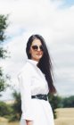 Симпатичная девушка в рубашке и солнцезащитных очках в поле — стоковое фото