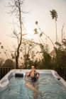 Mulher desfrutando de um banho em uma banheira de hidromassagem nas terras altas do Sri Lanka — Fotografia de Stock