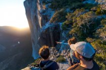 Três caminhantes olhando para o The Nose El Capitan de cima ao pôr do sol — Fotografia de Stock