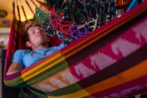 Чоловік спить в гамаку всередині автобуса під великою кількістю висячого обладнання — стокове фото