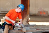 Ouvrier de la construction mâle faisant la coupe du bois — Photo de stock