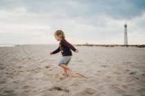 Kleiner Junge im Meer, der Ozean liegt am Strand. — Stockfoto