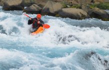 El hombre va en sus rápidos de kayak de agua blanca en un río islandés - foto de stock