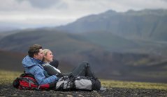 Подорожуюча пара відпочиває на гірському схилі Ісландії. — стокове фото