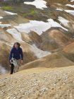 Pareja de senderismo por pendiente empinada en las tierras altas de Islandia - foto de stock