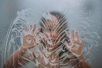 Close up of child in shower playing with soap on door — Stock Photo