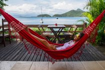Mujer relajante en hamaca en la isla tropical og Ilha Grande - foto de stock
