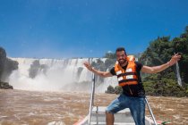 Junger Mann posiert vor den Wasserfällen von Iguacu in Argentinien — Stockfoto