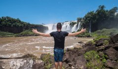 Молодой человек позирует перед водопадами Игуаку в Аргентине — стоковое фото