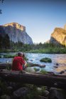 Hombre fotografiando el ambiente del parque nacional de Yosemite desde la vista del capitán - foto de stock