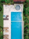 Vista aérea superior de la mujer relajándose alrededor de la piscina durante el fin de semana - foto de stock