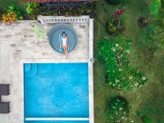 Luftaufnahme einer Frau, die sich am Wochenende am Pool entspannt — Stockfoto