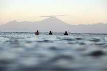 Surfeurs en planche de surf sur la mer attendant une vague, Volcan Rinjani — Photo de stock