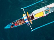 Вид с воздуха на серферов и лодку в океане, Ломбок, Индонезия — стоковое фото